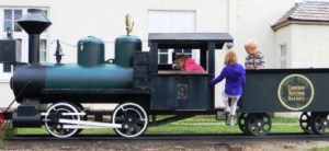 Children playing on a small model steam train in Jasper, Alberta.